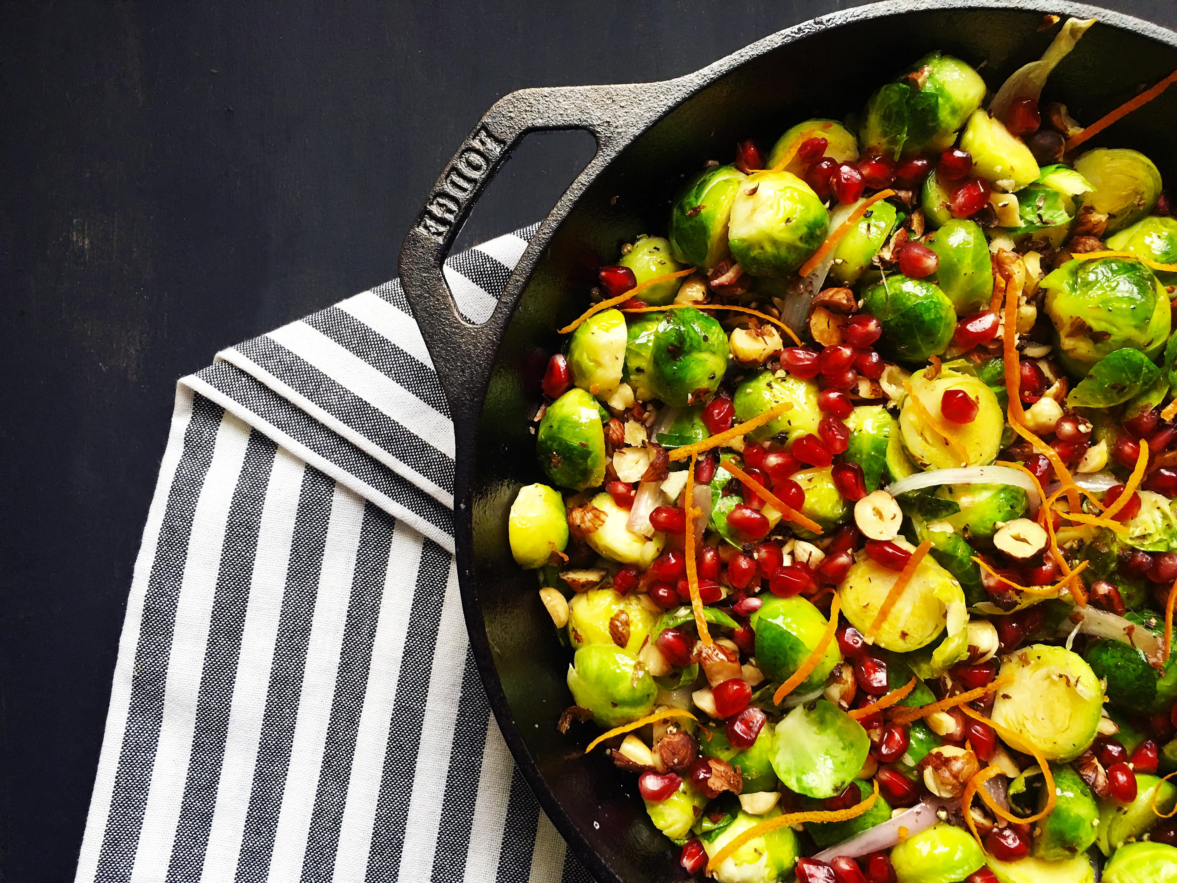 Brussels Sprouts with White Balsamic, Pomegranate, and Toasted Hazelnuts in a cast iron skillet